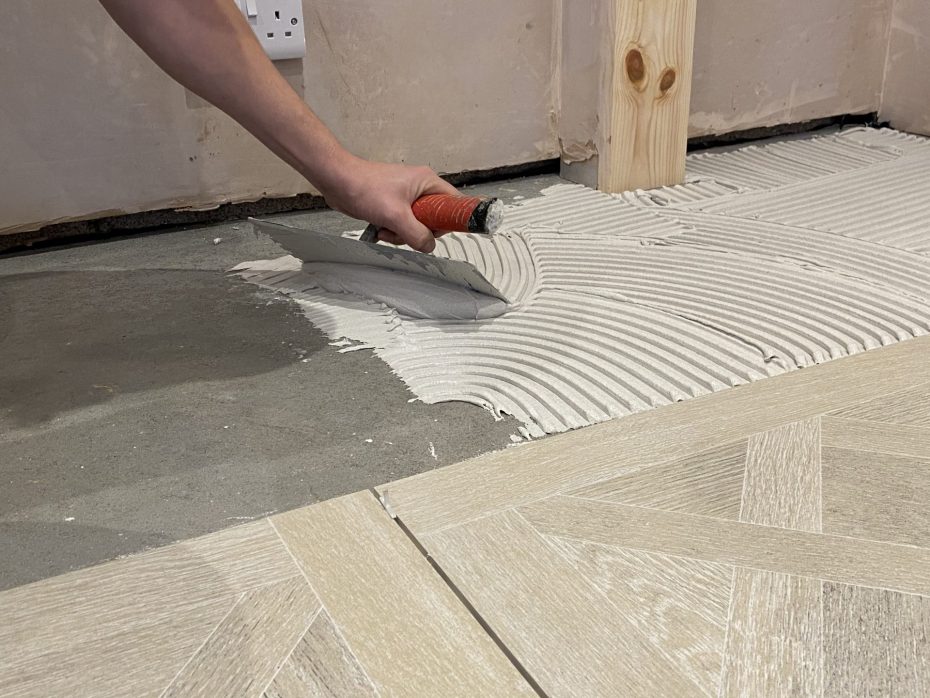 Tiler adding adhesive