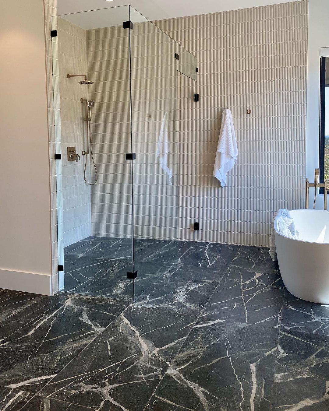 Switch up your bathroom floors with dramatic black marble-effect tiles.